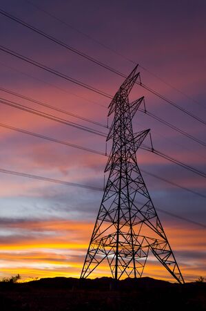 Power Pylons and Electricity transmission wires with clouds at sunsetの写真素材