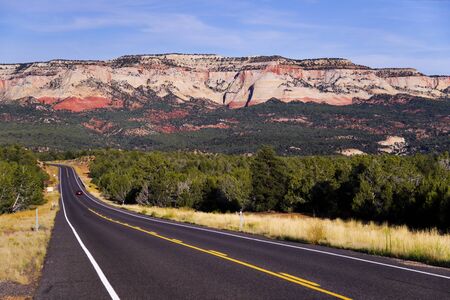 A two lane road running through a desert landscapeの写真素材