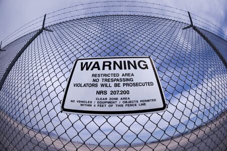 Airport Fence Warning Sign shot with a fish-eye lensの写真素材