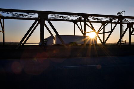 Motion Blurred Big Rig on Bridge at Sunsetの写真素材