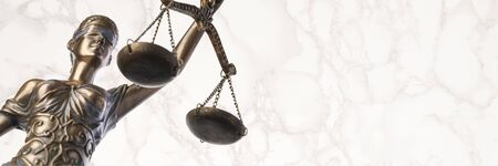 Bronze Themis statue - symbol of Justice - viewed from a low angle with a marble background