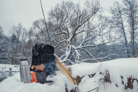 A picnic on a fishing trip, on a snow-covered winter river.の写真素材