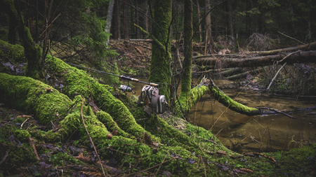 Fishing gear on the background of a picturesque forest stream.の写真素材