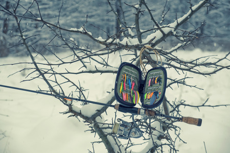 Fishing gear on the shore of a winter stream.の写真素材