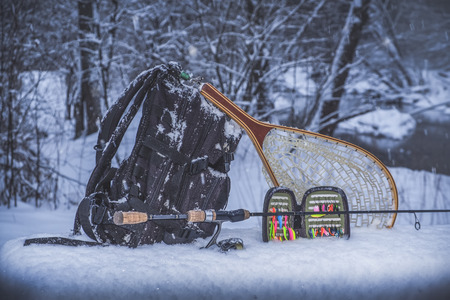 Fishing gear on the shore of a winter stream.の写真素材