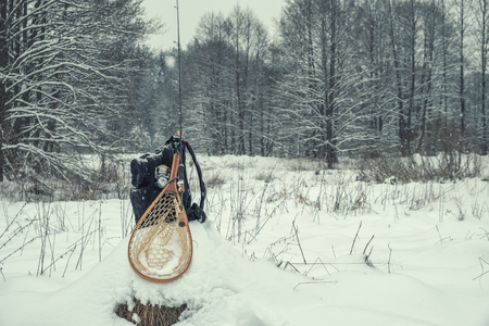 Fishing gear on the shore of a winter stream.の写真素材