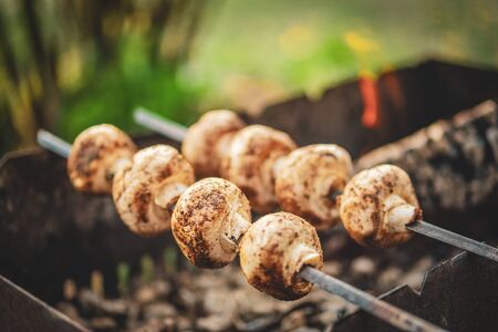 Mushrooms cook on burning coalsの写真素材