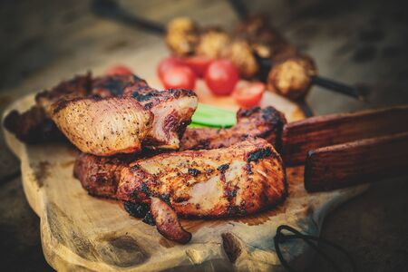 Grilled ribs and vegetables on a wooden boardの写真素材