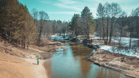 Fisherman with rod on the river bank.