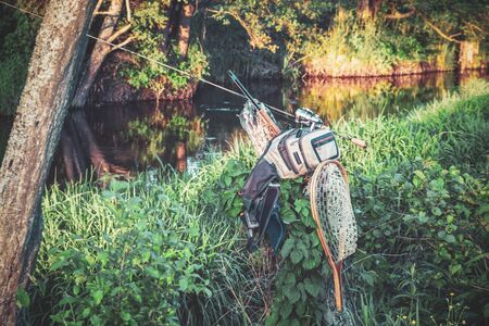 Fishing equipment on the bank of the spring river.の写真素材