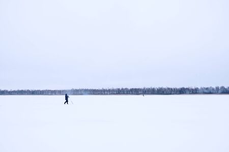 A lone fisherman on a frozen lake. Ice fishing.