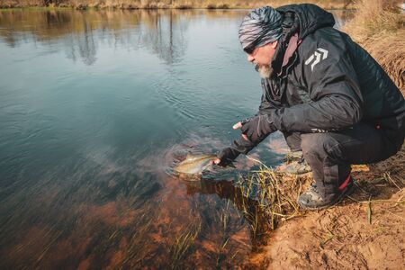 Fisherman holds asp in hand.の写真素材