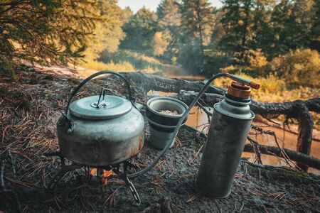 Kettle, gas burner and silicone mug close-up. Hiking in the forest.の写真素材