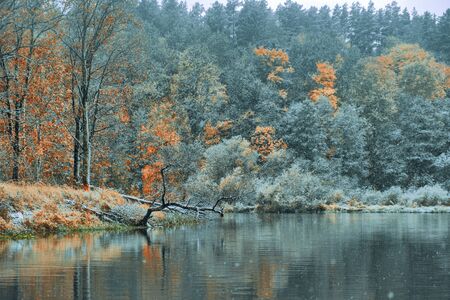 The first snow falls on the autumn riverの写真素材