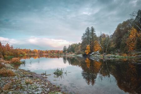 The first snow fell in the autumn on the river.の写真素材