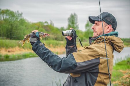 Fisherman photographs caught pike.の写真素材