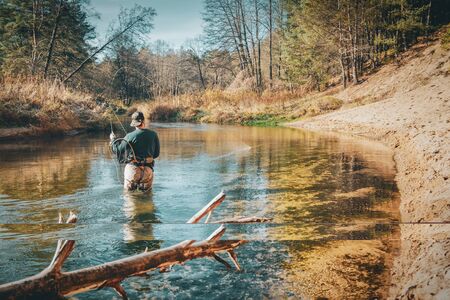 Fly fishing on a forest river backgroundの写真素材
