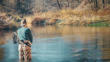 Fly fishing on a forest river background