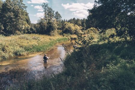 Fisherman makes a cast rod on the creek. Fly fishingの写真素材