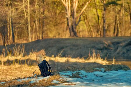 Backpack and fishing rod on the river. Fishing.の写真素材