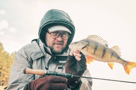 Fisherman holding bass in hand.の写真素材