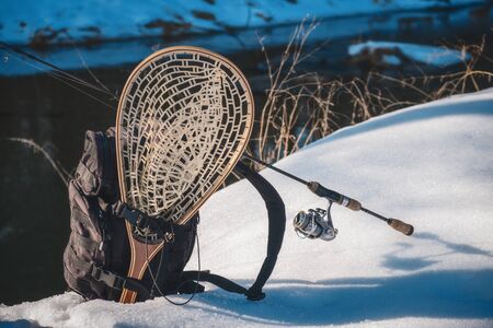 Fishing gear on the shore of a winter creek.の写真素材