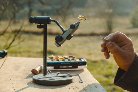 Close up of fisherman tying a fly for fishingの写真素材