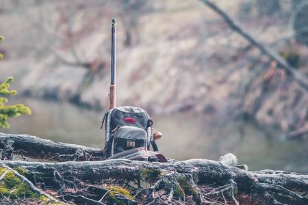 Fishing equipment on the shore of a forest stream.の写真素材