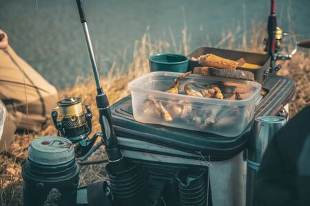 Fishermen eat lunch at the lake.の写真素材