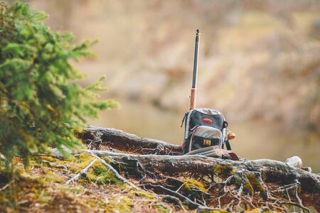 Fishing equipment on the shore of a forest stream.の写真素材
