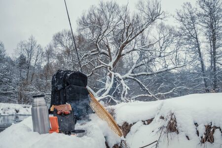 A picnic on a fishing trip, on a snow-covered winter river.の写真素材