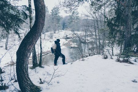 Fisherman with rod on the river bank.