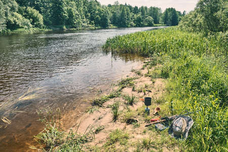 Fishing tackle and equipment on the river bank.の写真素材