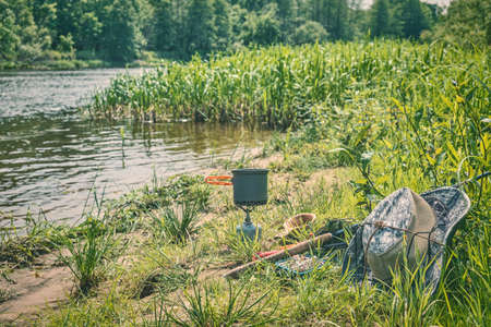Fishing tackle and equipment on the river bank.