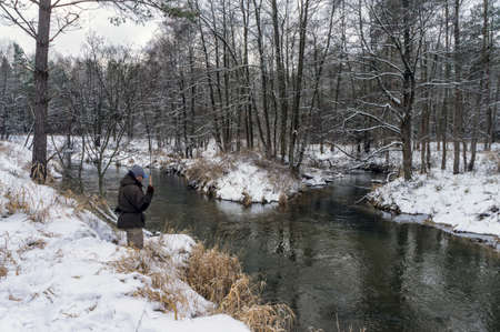 Fisherman with rod on a winter river. Tenkara fishing.の写真素材