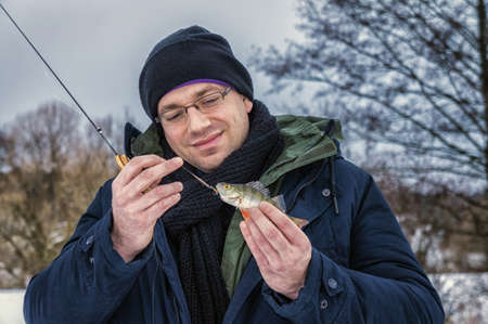 The man caught the first fish on ice fishing.の写真素材