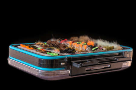 Box with fly-flies on a black background. Fishing equipment.の写真素材