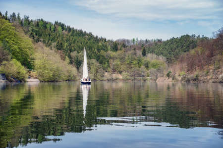 Sailing boat on a background of mountainsの写真素材
