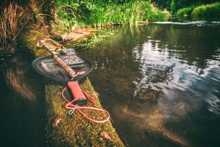 Fishing gear lying on the bank of a forest stream. Fly fishing and tenkara.の写真素材
