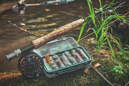 Fly rod and fly box on the bank of the stream.の写真素材