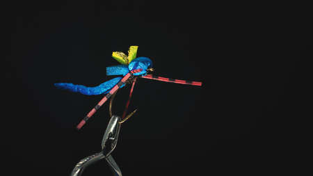 Handmade fishing fly close-up on a dark background.の写真素材