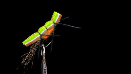 Handmade fishing fly close-up on a dark background.の写真素材