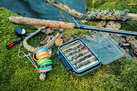 Fly box and rod on the river bank. Fly fishing and tenkara.の写真素材