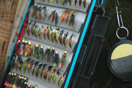 Fly box and rod on the river bank. Fly fishing and tenkara.の写真素材