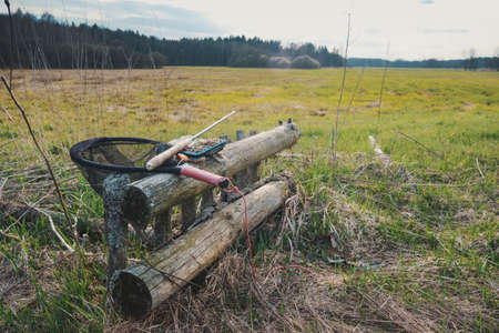 Fly box and rod on the river bank. Fly fishing and tenkara.
