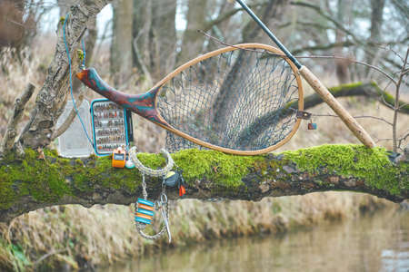 Fly box and fishing tackle on the river bank.の写真素材