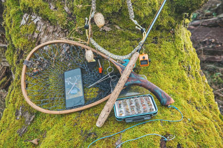 Fly box and fishing tackle on the river bank.の写真素材