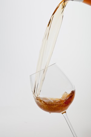 Wine pouring into wineglass, alcohol splashingの写真素材