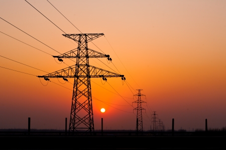 sunset under the high-voltage tower in the backgroundの写真素材