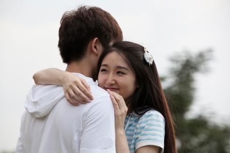 a young Asian couple is playing outdoorの写真素材